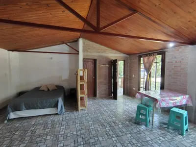 a room with a bed and a wooden ceiling at Refugio del Rio in Los Reartes