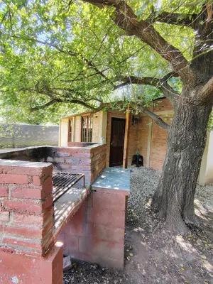 a brick house with a tree in front of it at Refugio del Rio in Los Reartes