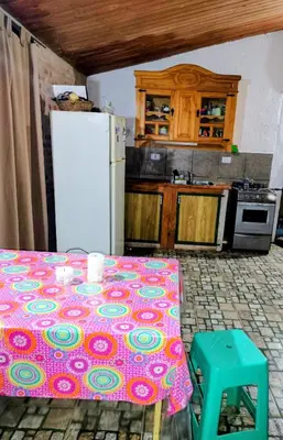 a kitchen with a table and a white refrigerator at Refugio del Rio in Los Reartes