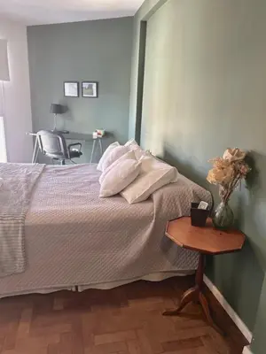 a bedroom with a bed and a table with a vase of flowers at Independencia Housing in Cordoba