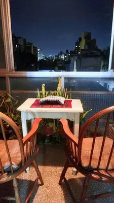 a white table and chairs on a balcony with a view of a city at Habitación silenciosa Nº1 en Dpto Compartido in Cordoba