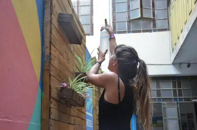 a woman standing next to a wall with a bottle at 531 Hostel in Cordoba