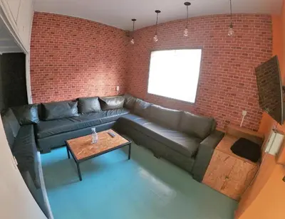 a living room with a couch and a brick wall at 531 Hostel in Cordoba