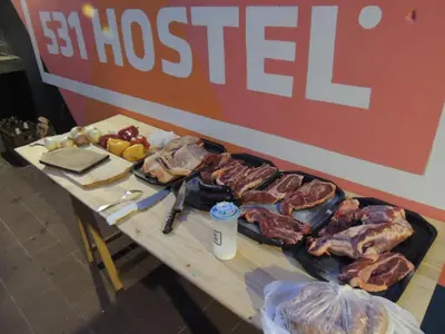 a table with meat and other food on it at 531 Hostel in Cordoba