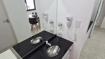 a bathroom with two silver urinals and a phone at Eloise II, excelente ubicación y con todo lo que necesitas! in Villa Carlos Paz