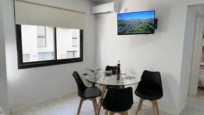 a dining room with a table and chairs with a tv on the wall at Eloise II, excelente ubicación y con todo lo que necesitas! in Villa Carlos Paz