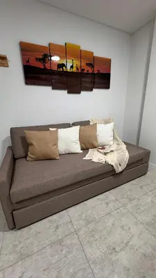 a couch in a room with three paintings on the wall at Eloise II, excelente ubicación y con todo lo que necesitas! in Villa Carlos Paz
