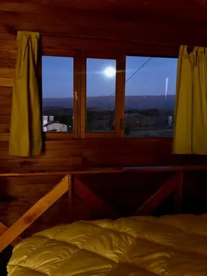a bedroom with a bed and a window with a view at Cabaña Snowflakes in Villa Yacanto