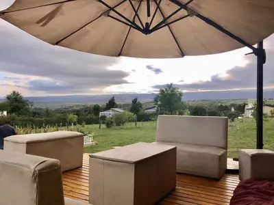 a patio with two chairs and an umbrella at Cabaña Snowflakes in Villa Yacanto