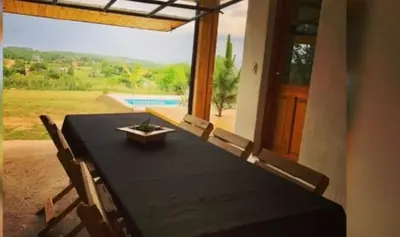 a black table with chairs and a view of a pool at Cabaña Snowflakes in Villa Yacanto
