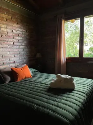 a bedroom with a bed with two towels on it at Cabañas Los Horneros in Santa Rosa de Calamuchita