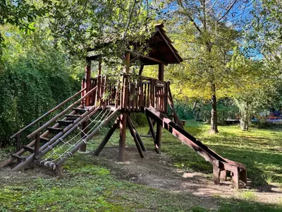 a wooden playground with a slide in a park at Cabañas Los Horneros in Santa Rosa de Calamuchita