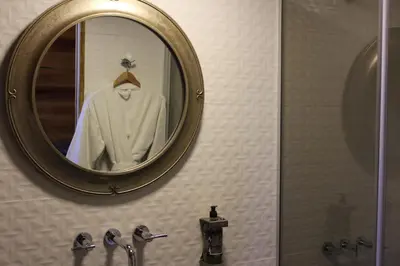 a mirror above a sink in a bathroom at Ayres del Champaqui Hotel Boutique Experiencial & Spa in Villa General Belgrano