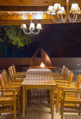 a wooden table with chairs and a fire place at Ayres del Champaqui Hotel Boutique Experiencial & Spa in Villa General Belgrano