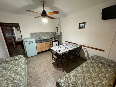 a kitchen with a table with chairs and a refrigerator at Cybeles Family Apart in Villa Carlos Paz