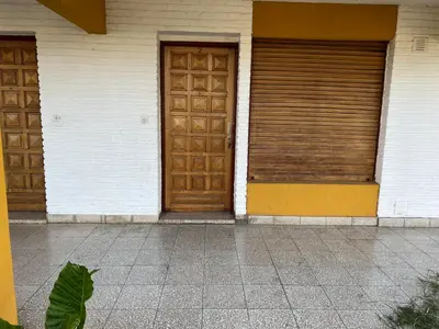 two wooden doors on a building next to a sidewalk at Cybeles Family Apart in Villa Carlos Paz