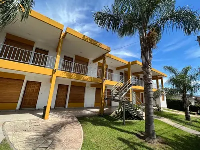 a building with a palm tree in front of it at Cybeles Family Apart in Villa Carlos Paz