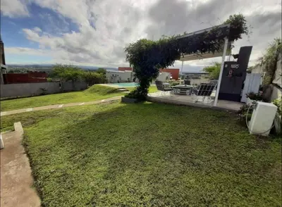 a backyard with a grassy yard with a pergola at Mauro y Sonia in Estancia Vieja