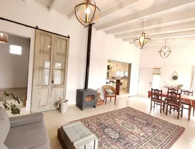 a living room with a wood stove and a table at Mauro y Sonia in Estancia Vieja