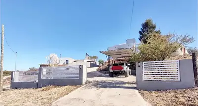 a fence in front of a house with a driveway at Mauro y Sonia in Estancia Vieja