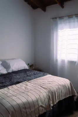 a bedroom with a large bed with a window at Piedras Moras in Villa General Belgrano