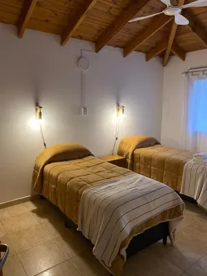 a bedroom with two beds in a room with wooden ceilings at Piedras Moras in Villa General Belgrano