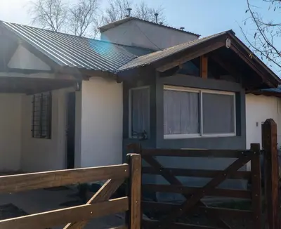 a house with a wooden fence in front of it at Piedras Moras in Villa General Belgrano