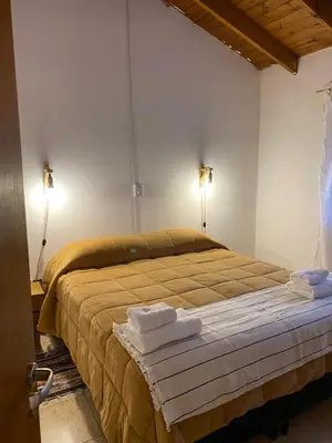 a bedroom with a bed with two towels on it at Piedras Moras in Villa General Belgrano