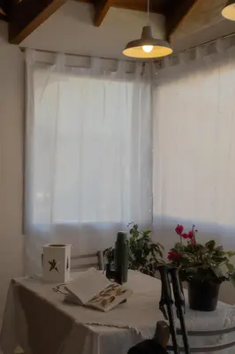 a table with a white table cloth and a window at Piedras Moras in Villa General Belgrano