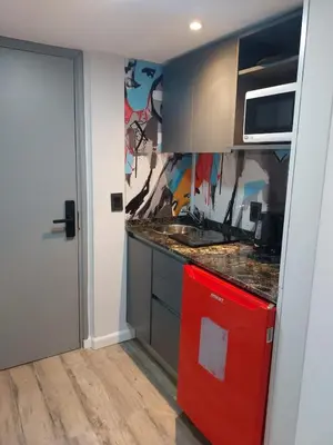 a kitchen with a red refrigerator and a sink at Departamento NYC 4 Premium - Edificio VILAUT by INMOVE Temporarios in Cordoba