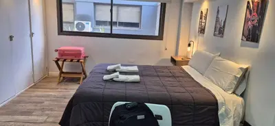 a bedroom with a bed with a backpack and a window at Departamento 5 Londres - Edificio VILAUT by INMOVE Temporarios in Cordoba