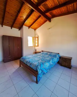 a bedroom with a bed and a wooden ceiling at Casa de campo in Los Hornillos