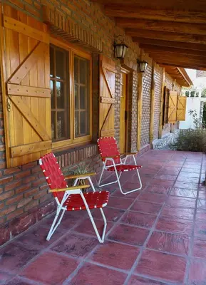 two red chairs and a table on a porch at Casa de campo in Los Hornillos