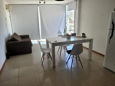 a living room with a table and chairs and a couch at Carilo in Villa Carlos Paz