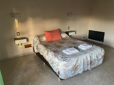 a bedroom with a bed and a television in it at Lo de Claudia in Alta Gracia