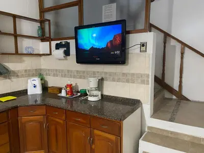 a kitchen with a tv on the wall and a counter at Lo de Claudia in Alta Gracia