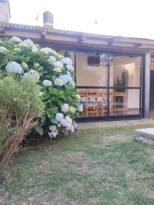 a large bush of flowers in front of a building at Lo de Claudia in Alta Gracia