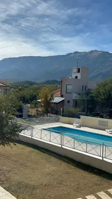 a swimming pool on the side of a house with a mountain at Complejo Malucos in Pantanillo