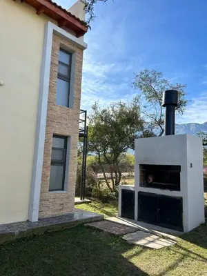 a building with a fireplace next to a house at Complejo Malucos in Pantanillo