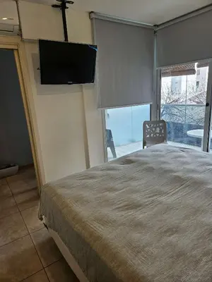 a bedroom with a bed with a flat screen tv on the wall at Picasso Nueva Cordoba in Cordoba