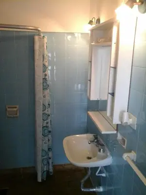 a blue tiled bathroom with a sink and a shower at Mágico atardecer in Villa Carlos Paz