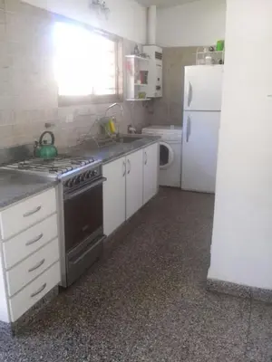 a kitchen with a stove and a white refrigerator at Mágico atardecer in Villa Carlos Paz