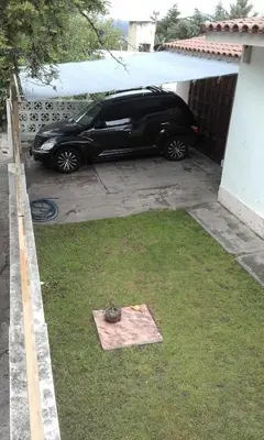 a black car parked in a driveway next to a house at Mágico atardecer in Villa Carlos Paz