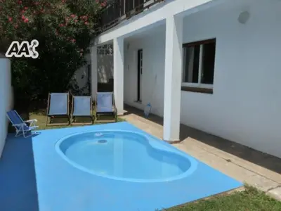 a large blue pool in front of a house at Mágico atardecer in Villa Carlos Paz