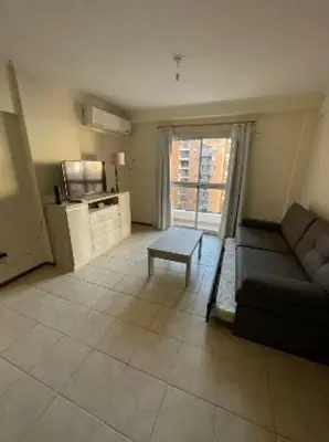 a living room with a couch and a table at Departamento -Oro- Frente al Parque Sarmiento, By Apartcba in Cordoba