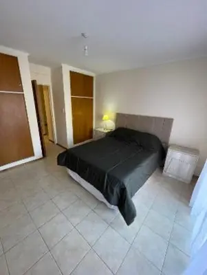 a bedroom with a black bed in a room at Departamento -Oro- Frente al Parque Sarmiento, By Apartcba in Cordoba