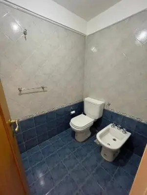 a bathroom with a toilet and a sink at Departamento -Oro- Frente al Parque Sarmiento, By Apartcba in Cordoba