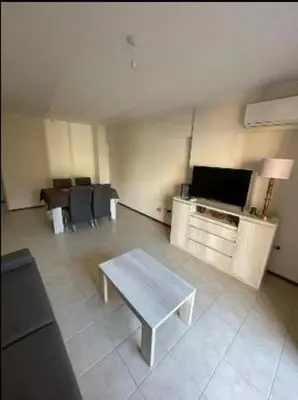 a living room with a table and a tv at Departamento -Oro- Frente al Parque Sarmiento, By Apartcba in Cordoba