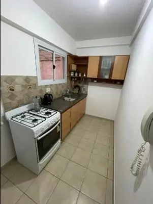 a small kitchen with a stove and a sink at Departamento -Oro- Frente al Parque Sarmiento, By Apartcba in Cordoba