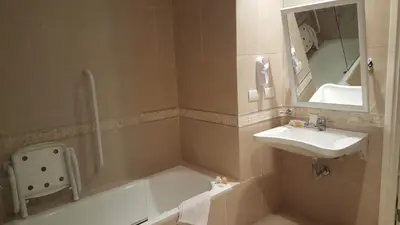 a bathroom with a shower and a sink and a mirror at Howard Johnson Hotel Piedras Moras in Almafuerte